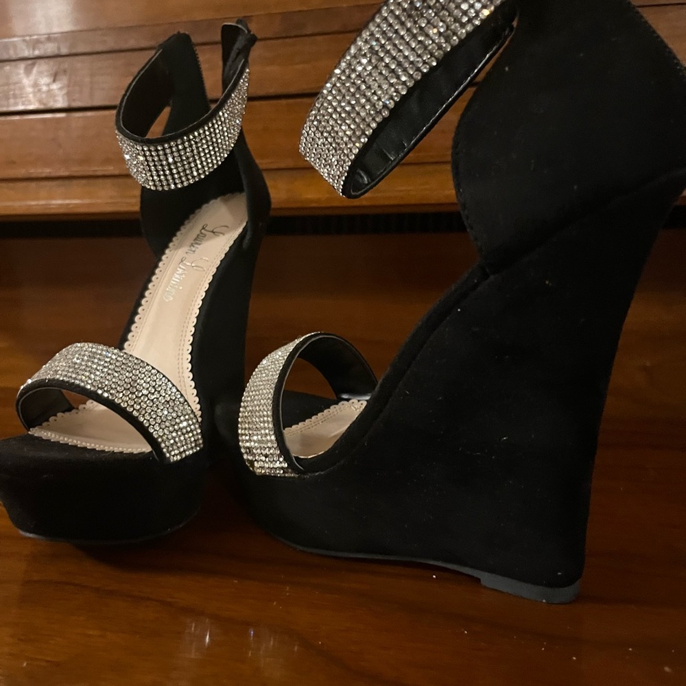 Black high heels sandals with rhinestone ankle straps and foot straps.